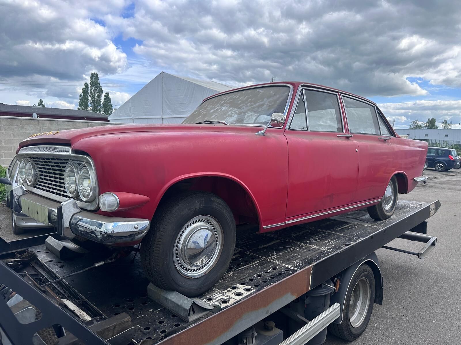 Voiture ancienne rouge transportée sur le plateau de la dépanneuse
